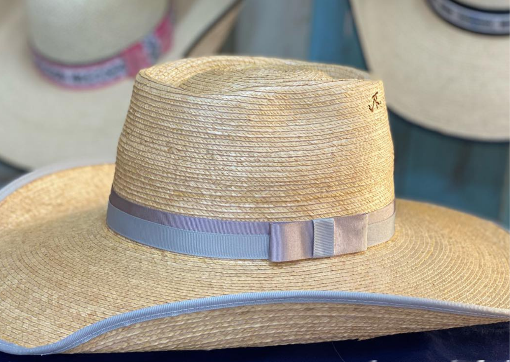Jaxonbilt_Hats_are_Australian_made_palm_leaf_hats_and_crossbred_hats_for_cowgirls_and_cowboys_with_wide_brims_for_sun_protection_5”_brim_trim_on_edge_wide_crown_band_box_top_shape_ribbon_crown_band_with_a_bow_dark_oak